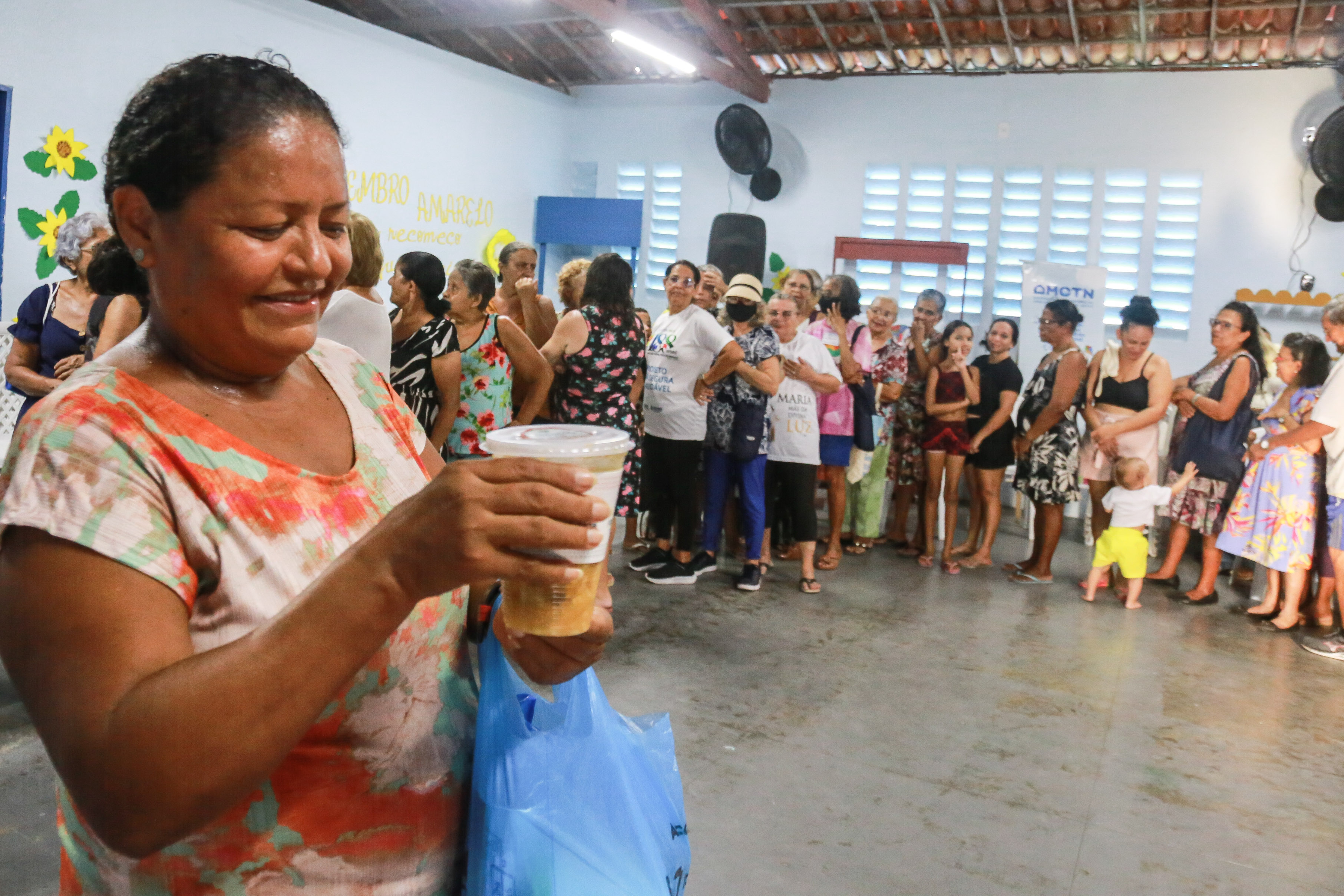 uma mulher segura a embalagem de sopa que recebeu